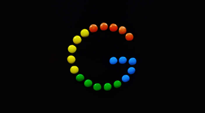 Google 'G' logo recreated with colorful candy pieces on a black background.